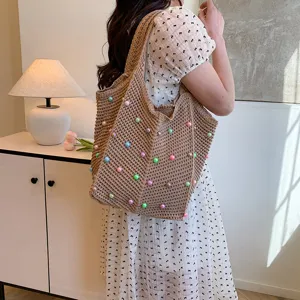 Detail view of a stylish knitted tote bag with colorful beads, perfect for daily use.