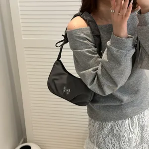 Chic pleated shoulder bag detail featuring a stylish metallic butterfly accent for daily.