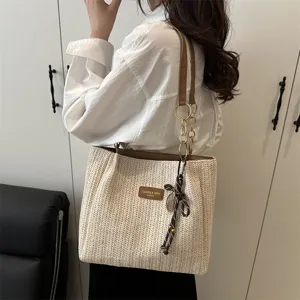 Casual woven straw shoulder tote bag for women, stylish summer beach vacation handbag with chic chain detail.
