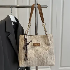 Straw woven shoulder tote bag with chain strap and PU leather handles for casual summer beach use.