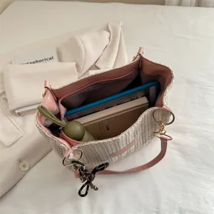 Casual woven straw tote bag with pink leather shoulder straps for summer beach vacation and daily use.