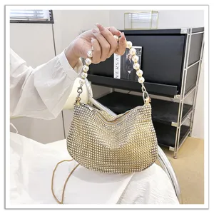 Close-up detail shot of a sparkling rhinestone evening handbag featuring an elegant pearl handle.