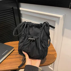 Black nylon bucket shoulder bag for women, minimalist casual crossbody daily handbag with drawstring.