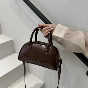 Detailed view of the dark brown PU leather Boston handbag featuring sturdy handles and strap.
