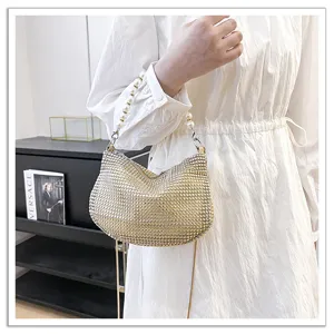 Elegant sparkling rhinestone evening shoulder bag with pearl handle and chic chain strap.