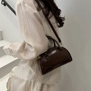Chic brown Boston handbag detail, compact PU leather crossbody design for women daily style.