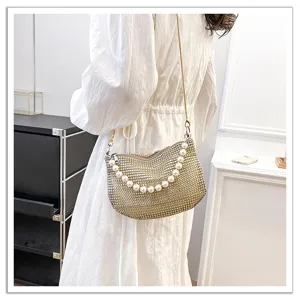 Detailed closeup showing the sparkling rhinestone bag with pearl handle and delicate chain strap.