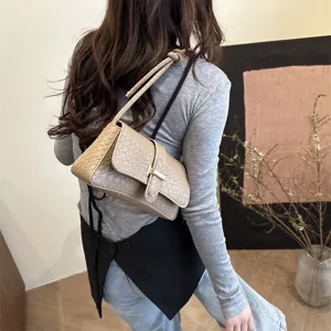 Elegante bolso de hombro baguette con relieve de cocodrillo y hebilla metálica chic en modelo.