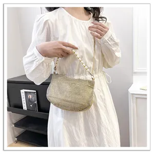 Sparkling rhinestone evening handbag with elegant pearl handle and chic chain strap.
