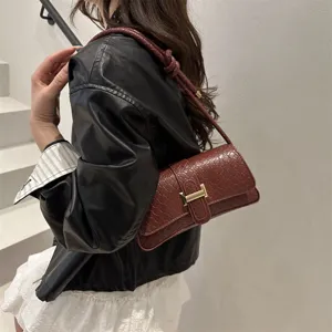 Vista detallada del elegante bolso de hombro tejido con textura fina y cierre metálico.