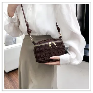 Detailed shot of the stylish brown pleated cloud shoulder bag, showcasing fine texture and zips.
