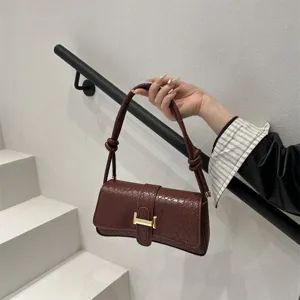Elegante bolso de hombro con estampado de serpiente roja oscura y hebilla metálica.
