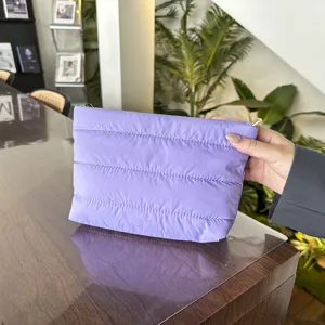 Detail shot of a lavender quilted clutch bag, soft padded texture, elegant fashion style.
