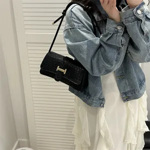 Vista detallada del elegante bolso de hombro negro con un elegante cierre metálico.