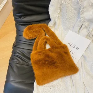 Fluffy faux fur handbag detail view, cozy winter caramel brown fuzzy tote bag style.