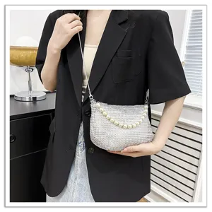 Silver rhinestone shoulder bag with elegant pearl handle detail, perfect for evening parties.
