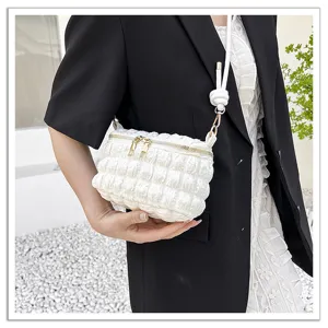 Detail shot of white pleated cloud bag showing unique bubble texture and metallic zipper.