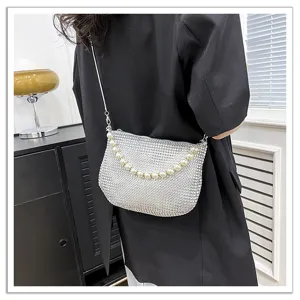 Rhinestone mesh crossbody bag detail, sparkling crystal surface with elegant faux pearl strap.