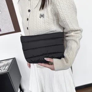 Black quilted puffer clutch bag, minimalist daily commuting pouch with soft padded design.