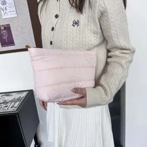 Detail view of the pink quilted puffer clutch bag, soft padded daily casual hand purse.