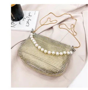 Detailed shot of the elegant rhinestone evening bag with luxury pearl handle and chain strap.
