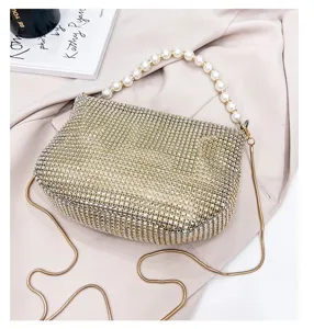 Sparkling rhinestone evening shoulder bag with elegant pearl handle and luxury gold chain.