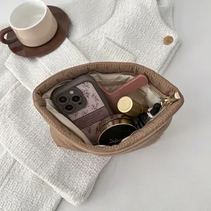 Brown quilted makeup bag, minimalist cosmetic pouch with zip closure and spacious interior.
