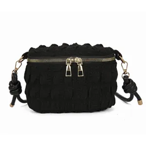 Black crinkled bubble crossbody bag with gold zippers and stylish knotted shoulder strap.