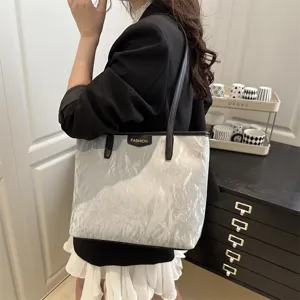 Detailed view of fashionable silver tote bag with crinkled texture for women's daily commute.