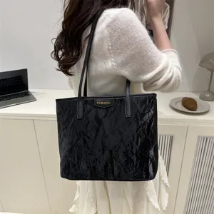 Detail view of black crinkled tote bag, stylish PU leather shoulder bag for women daily commute.