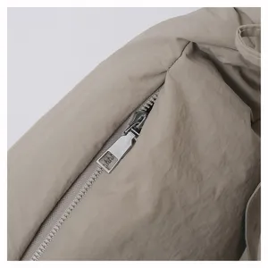 Detailed view of casual nylon crossbody dumpling bag zipper, minimalist design, beige.