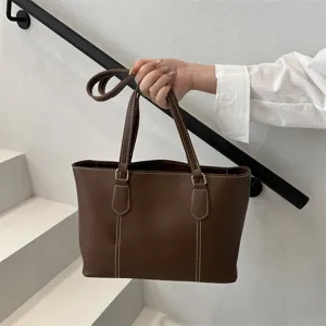 Détail de sac cabas souple marron, sac à épaule décontracté et minimaliste pour femmes chic.