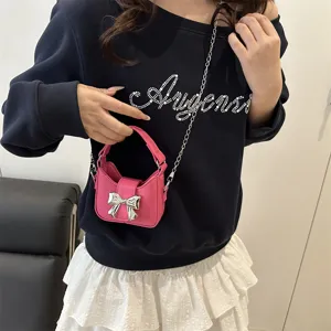 Pink mini crossbody bag for girls with cute silver bow and metal chain strap for autumn style.