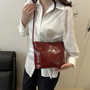 Red patent leather shoulder bucket bag with silver bow accent, casual daily fashion accessory.