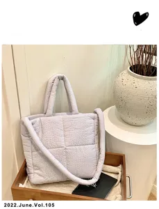 Detail view of the quilted tote bag in a styled lifestyle setting with decor and vase.