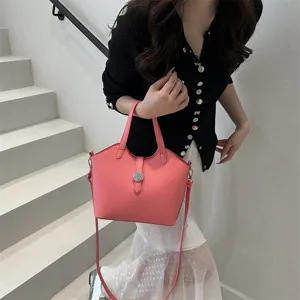 Nahaufnahme der eleganten rosa Beuteltasche mit schickem Metall-Schnallenverschluss.