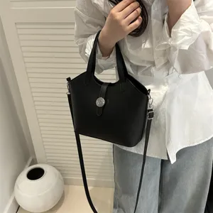 Schwarze Leder Eimer Tasche Detailansicht, klassische Handtasche mit Metallschnalle und Riemen.
