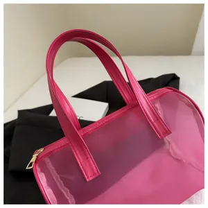 Pink translucent PVC and mesh handbag, stylish jelly tote bag with dual handles and secure zipper.