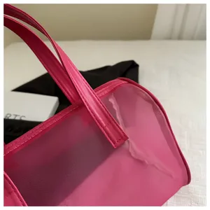 Pink translucent PVC mesh handbag, portable fashion jelly tote bag for daily use.