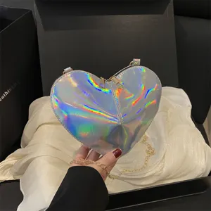 Holographic heart-shaped crossbody bag featuring a shiny patent leather surface and metallic chain.