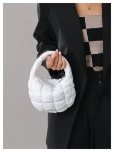 Detailed shot of a stylish white quilted cloud handbag, showcasing puffy texture and short handle.
