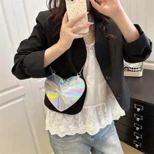 Close-up of the trendy holographic heart crossbody bag with glossy patent and chain strap.