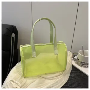 Close-up detail of the translucent neon green PVC handbag, showing clear mesh texture and design.