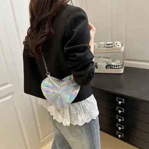 Detail view of the trendy silver holographic heart-shaped crossbody bag with metal chain.