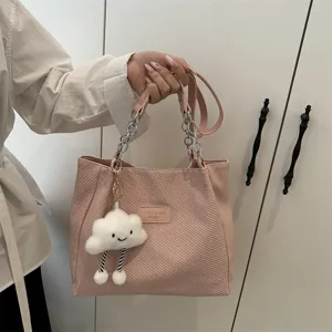 Detailed view of the pink corduroy tote bag featuring a cute cloud plush charm and stylish chain strap.
