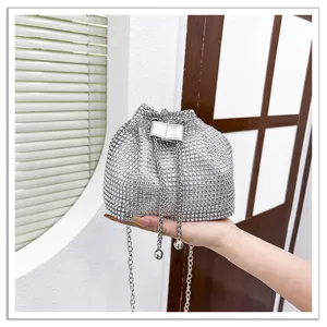 Vue détaillée du sac seau étincelant en strass argentés avec bandoulière chaîne en intérieur.