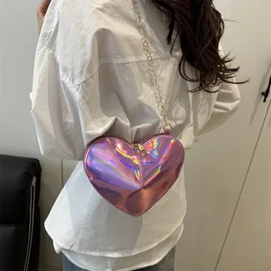 Close-up of the shiny pink heart crossbody bag, highlighting glossy patent leather and chain.