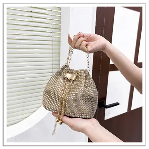 Détail du sac seau étincelant en strass avec des cristaux brillants et une chaîne dorée chic.