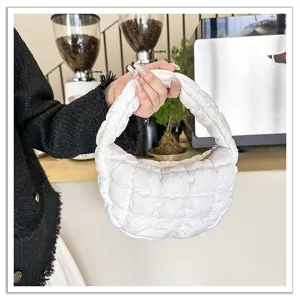Detail view of the white quilted cloud bag, showing soft puffer texture and chic hand-held design.
