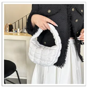 White quilted cloud underarm bag detail view, soft puffy minimalist fashion mini handbag.